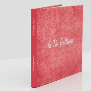 n The Dollhouse hard cover signed book by Dina Goldstein. A collection of essays, published pieces, interviews, production secrets and anecdotes about the In the Dollhouse series.